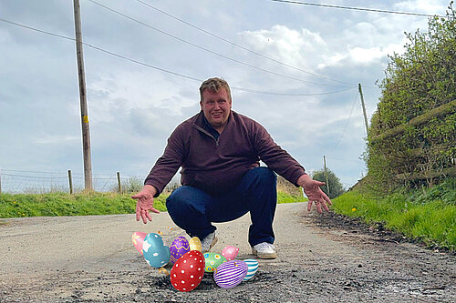 Jack posing in front of an Easter egg filled pothole