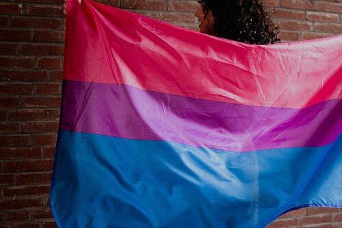 Woman holding a bisexual flag